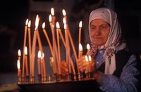 Lighting candles at Russian Orthodox church; Sovetskaya Gavan, Russia