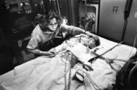 Hours after surgery, Olga hovers lovingly over an<br/>unconscious Sergei, murmuring gentle Russian phrases.