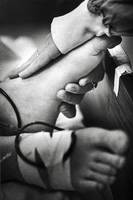 His mother gently strokes his foot, the only part of his body she could touch.