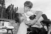 A counselor keeps Shane from falling from his chair during a seizure.